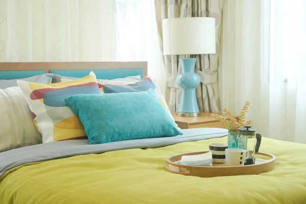 Taca z filiżanki kawy na żółty i zielony dekoracji w przytulnej sypialni pościel — Zdjęcie stockowe
