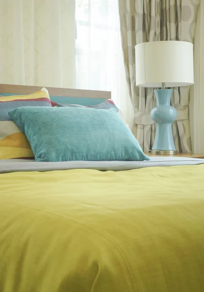 Travesseiro verde na cama com cobertor amarelo — Fotografia de Stock