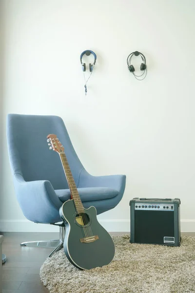 Στούντιο μουσικής με γκρι πολυθρόνα, κιθάρα και ακουστικά — Φωτογραφία Αρχείου