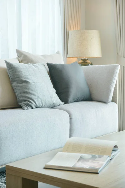 Almohadas en el sofá y revista en la mesa central en la sala de estar moderna — Foto de Stock