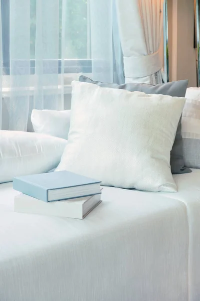 Weiße Kissen und Bücher auf weißem Sofa im modernen Wohnzimmer — Stockfoto