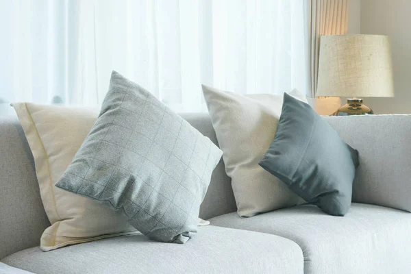 Almohadas de color gris en el sofá gris claro en la sala de estar de estilo moderno — Foto de Stock