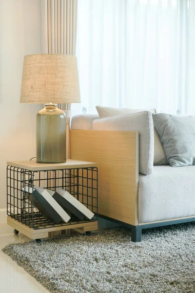 Lámpara de mesa en mesa de madera y sofá gris claro en la sala de estar moderna — Foto de Stock