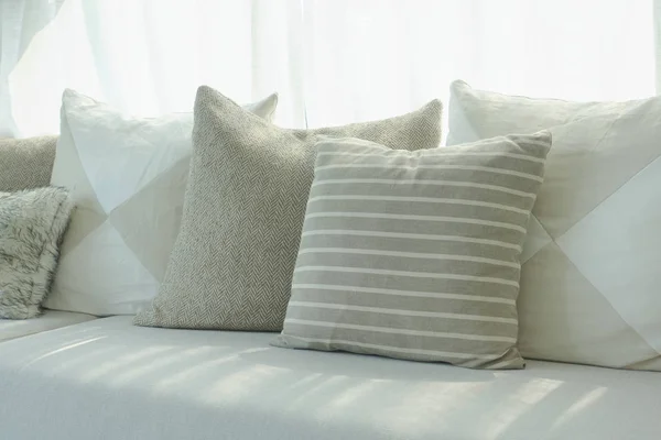 Raya y almohadas de color beige en el sofá junto a la ventana — Foto de Stock