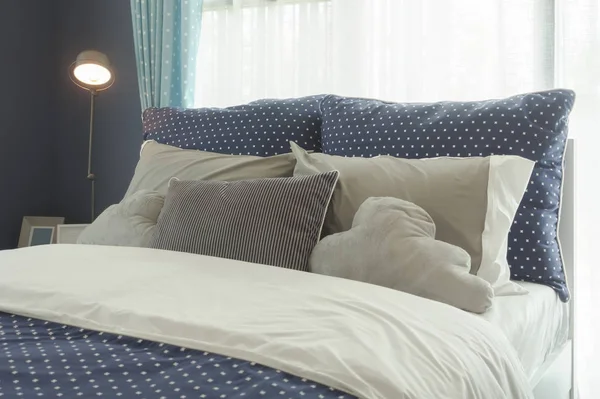 Синя полка точкового стилю Постільна білизна з сірими кольоровими подушками на ліжку — стокове фото