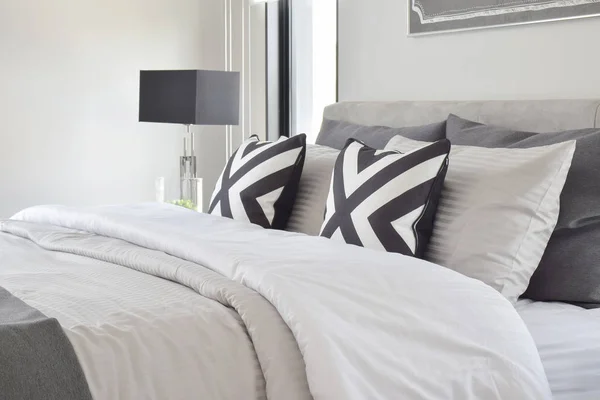 Grafisk stil kuddar på på klassisk färg sängkläder med svart läslampa — Stockfoto