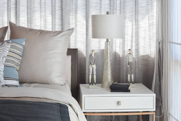 Quarto elegante design de interiores com almofadas listradas na cama e lâmpada de mesa decorativa . — Fotografia de Stock