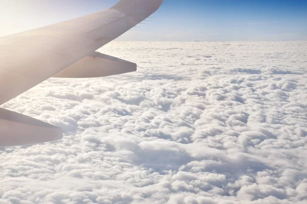 Крыло самолета с солнечным светом над облаком — стоковое фото