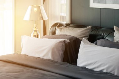 gri yastık ve sabahları lamba ile modern yatak odası