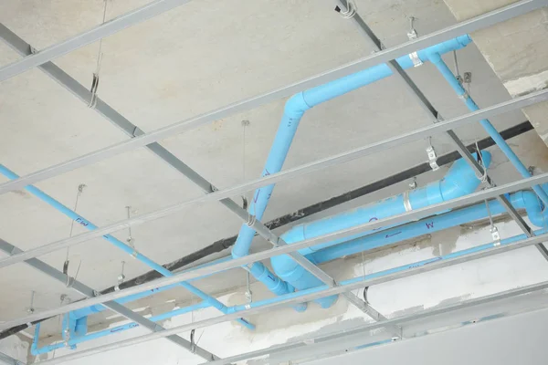 Installation sanitary work above a ceiling at construction site