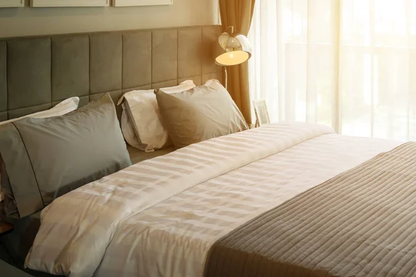 금속 데스크 램프와 회색 베개 침대에 침실에서 아침 장면 — 스톡 사진