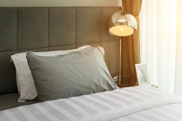 금속 데스크 램프와 회색 베개 침대에 침실에서 아침 장면 — 스톡 사진