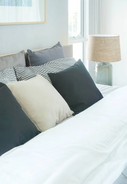 Сучасна інтер'єрна спальня з подушками на ліжку та читальною лампою біля ліжка — стокове фото