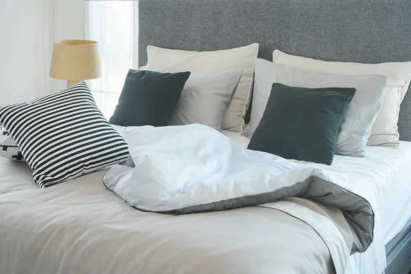 Грязная кровать с подушками в современной внутренней спальне — стоковое фото