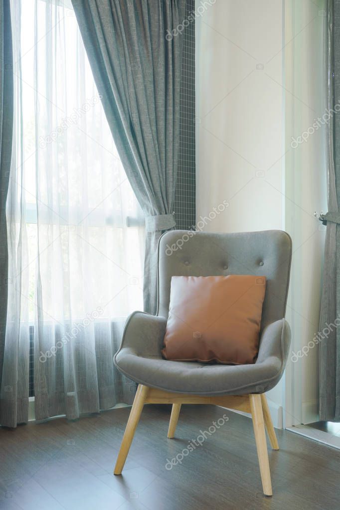 Stylish gray armchair with pillow in the living room