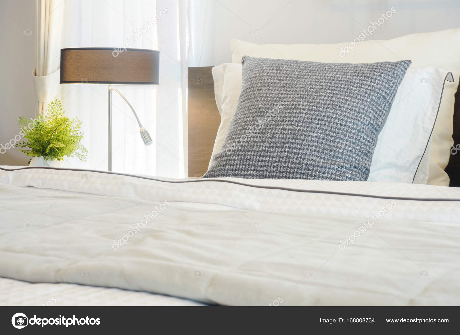 Nahaufnahme graues Kissen auf dem Bett mit moderner Bettwäsche im