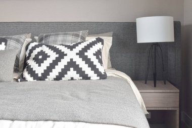 Grafik desen ve gri gölge yastıklar yatakta modern tarzı lamba okuma ile