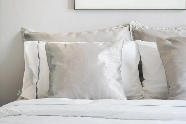 Jasny szary satynowe poduszki na łóżku z bliska — Zdjęcie stockowe