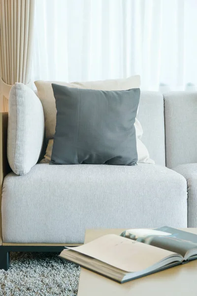 Almohadas blancas y negras en sofá gris en la sala de estar — Foto de Stock