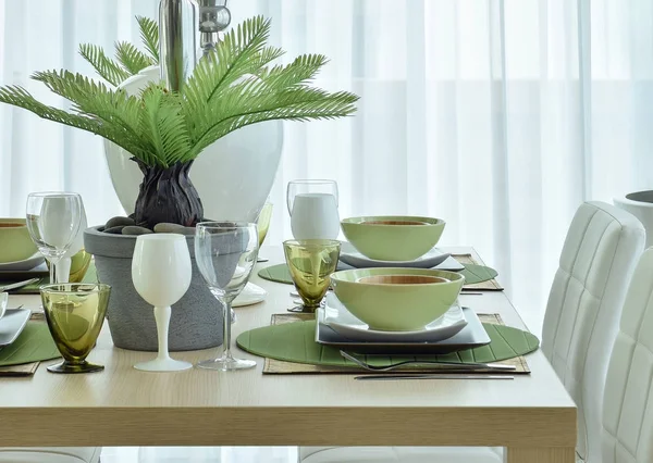 Modern ceramic tableware in green color scheme setting on wooden dining table — Stock Photo, Image