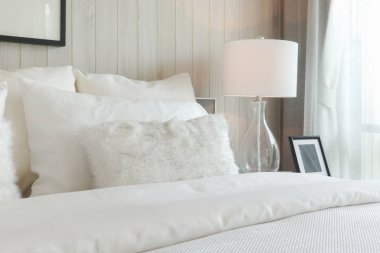 Lüks stil şişkin yastık ve yatak odasında beyaz masa lambası ile yatak takımları