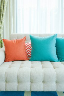 Yeşil ve turuncu yastık modern tarzı oturma odasında kanepede