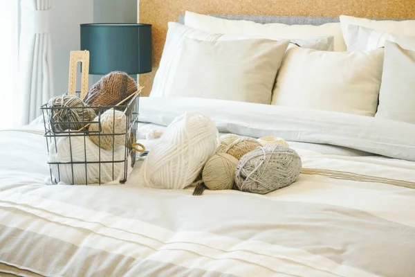 Breien van wol op bed in licht bruin slaapkamer interieur decoratie — Stockfoto