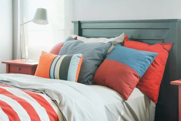 Красочные подушки на кровати в современной внутренней спальне — стоковое фото