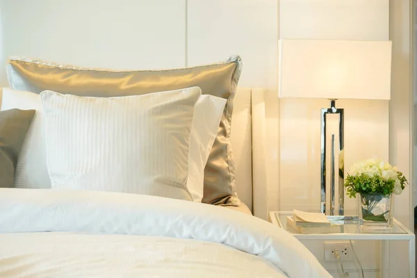Almohadas de primer plano en la cama con lámpara de lectura moderna en casa — Foto de Stock
