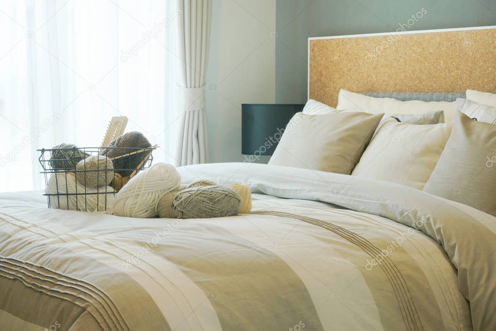 Yarn basket setting on comfortable bed in modern bedroom interior