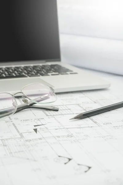 Black pencil and computer laptop on architectural drawing paper for construction — Stock Photo, Image