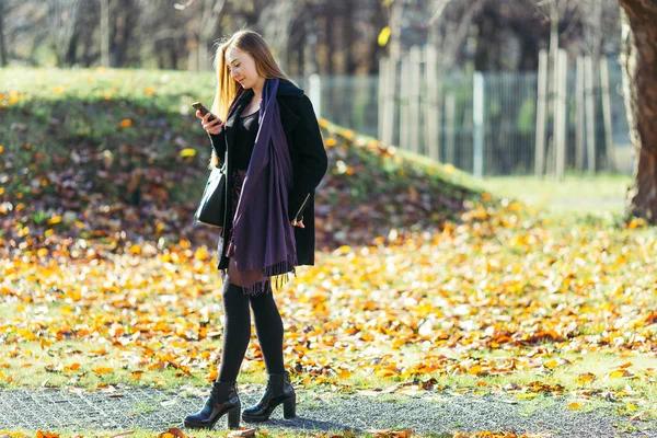 Femme blonde marchant dans le fond du parc — Photo