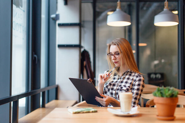 Блондинка, сидящая на стуле в кафе
