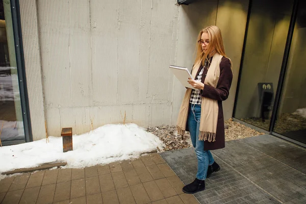 Jeune femme d'affaires regardant dans les journaux à l'extérieur — Photo