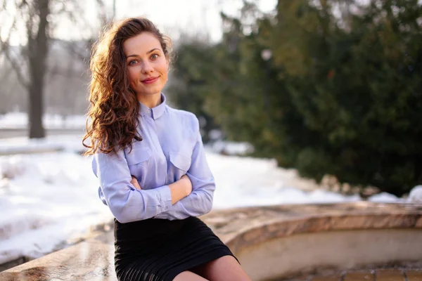 Femme assise sur le banc avec fond de parc et sourire à la came — Photo