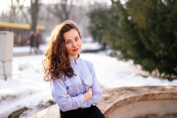 Femme assise sur le banc avec fond de parc et sourire à la came — Photo