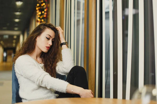 Chica joven sentada detrás de la cafetería con una taza de café — Foto de Stock