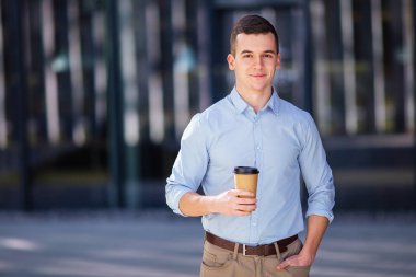 Kahve ya da çay içkisini tutunarak işadamı arka plan bulanıklık