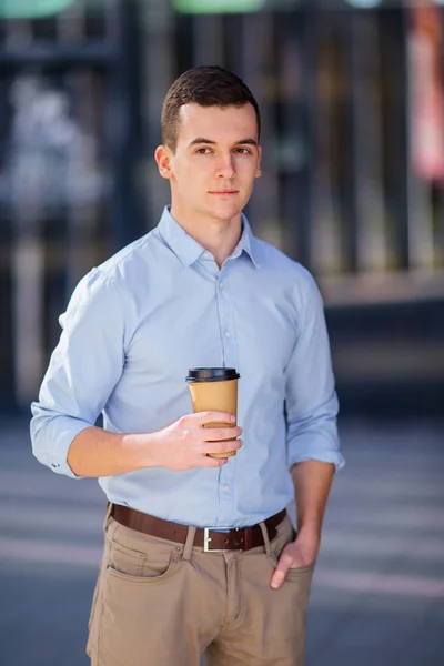 Geschäftsmann hält seinen Kaffee oder Tee auf verschwommenem Hintergrund — Stockfoto