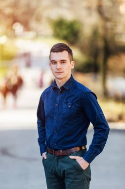 Park arka planda duran bir genç iş adamı