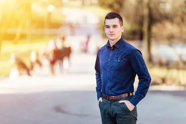 Один молодий бізнесмен стоїть на фоні парку — стокове фото