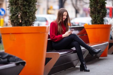 Esmer kadın Caddesi ve manifatura telefon oturuyordu