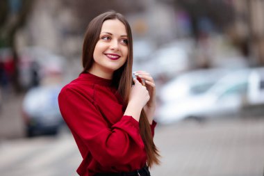 Saçları fırça ile fırçalama ve gülümseyen esmer kadın