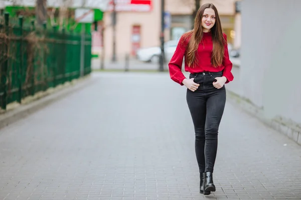 Üstünde belgili tanımlık sokak arka plan ve gülümseme yürüyen genç kadın — Stok fotoğraf