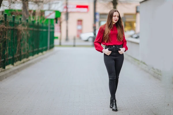 Giovane donna che cammina sullo sfondo della strada e sorride — Foto Stock