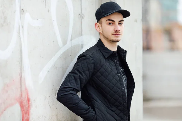 Hombre de moda de pie cerca de la pared con fondo borroso —  Fotos de Stock