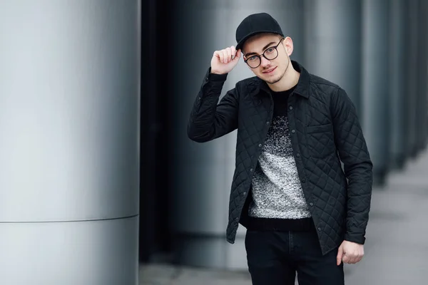 Hombre de moda de pie cerca de la pared con fondo borroso —  Fotos de Stock