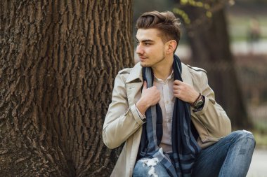Ağaçları ile yanında oturan moda adam arka plan bulanıklık