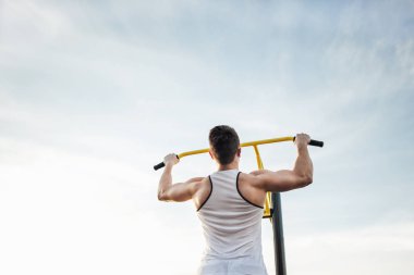 Adam stadyum bölgesinde güneş arka plan ile egzersiz yapmak