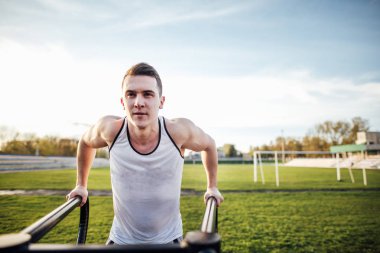Adam stadyum bölgesinde güneş arka plan ile egzersiz yapmak